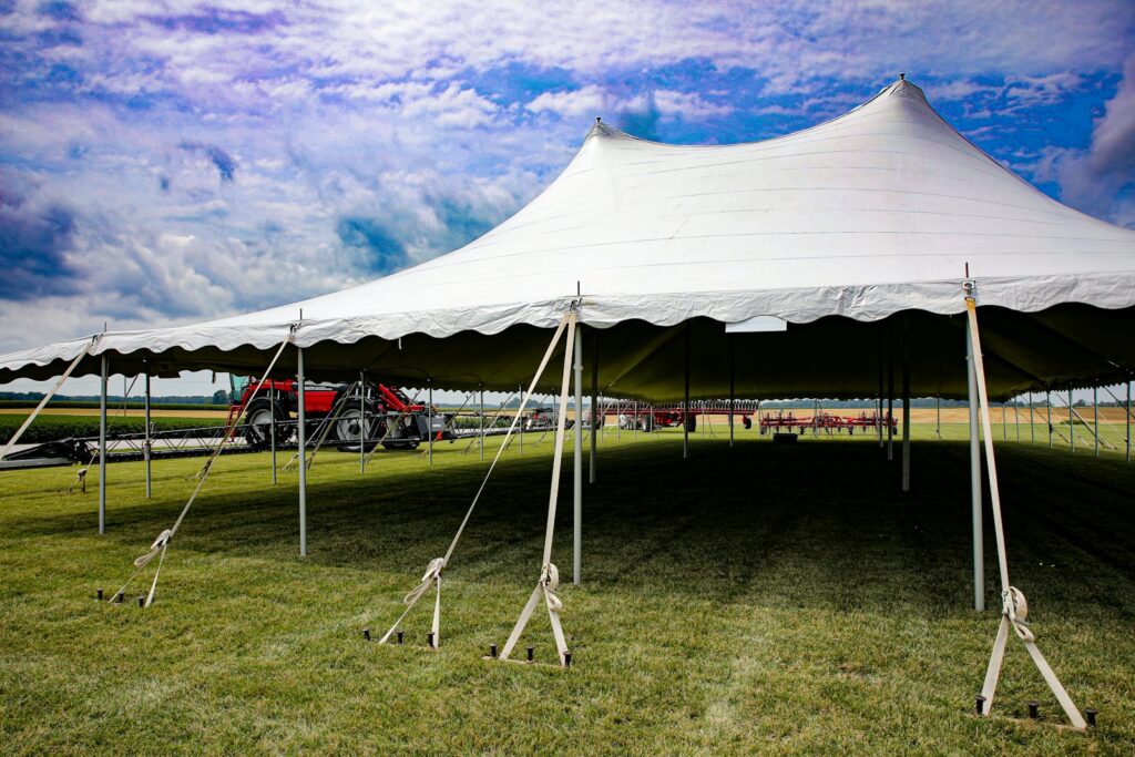 a large white tent sitting on top of a lush green field